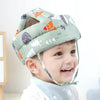 A toddler is wearing a light green and white patterned 360 degree head cap made of pure cotton for protection.