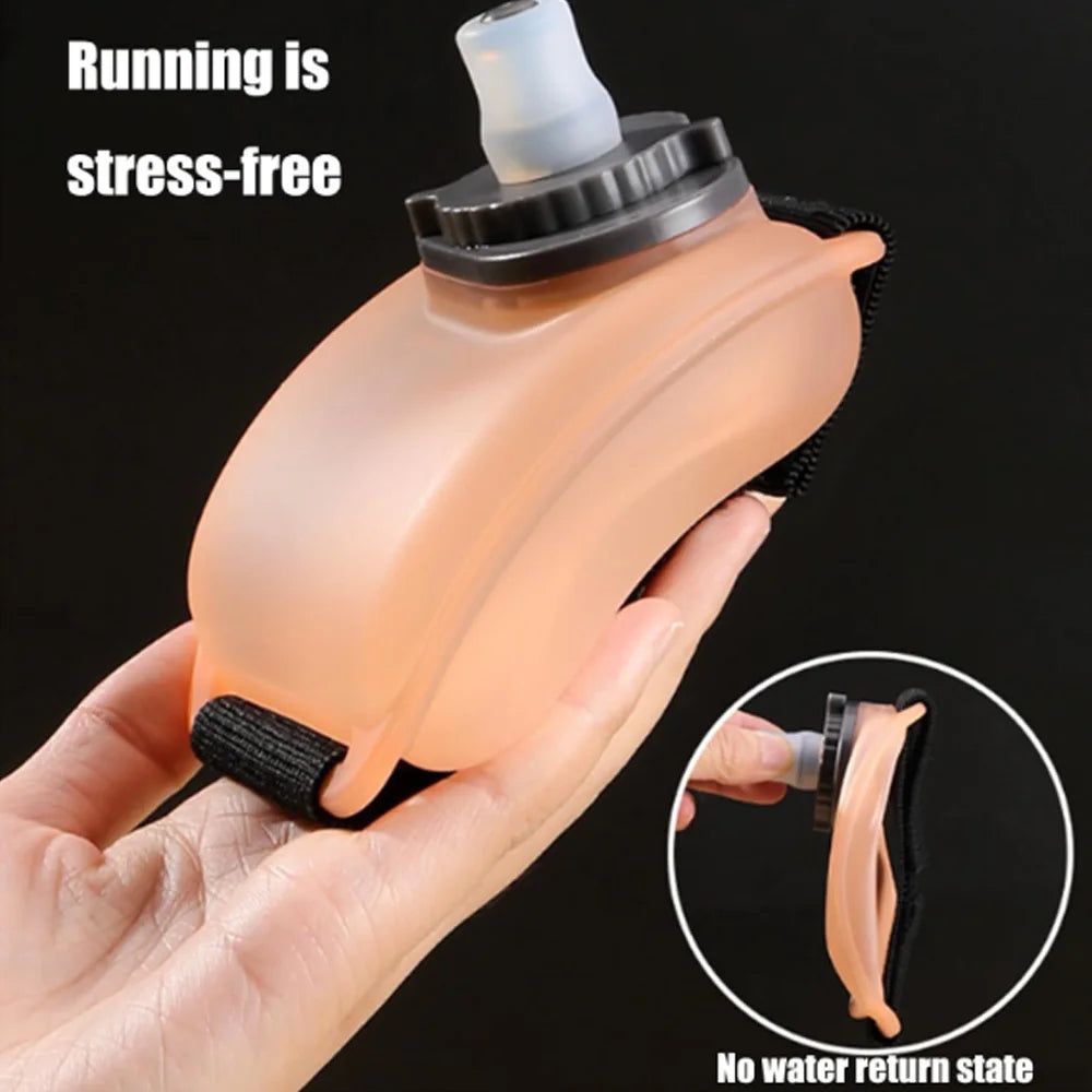A hand holds a peach-colored silicone hydration bottle with a mouthpiece, demonstrating a stress-free running accessory.