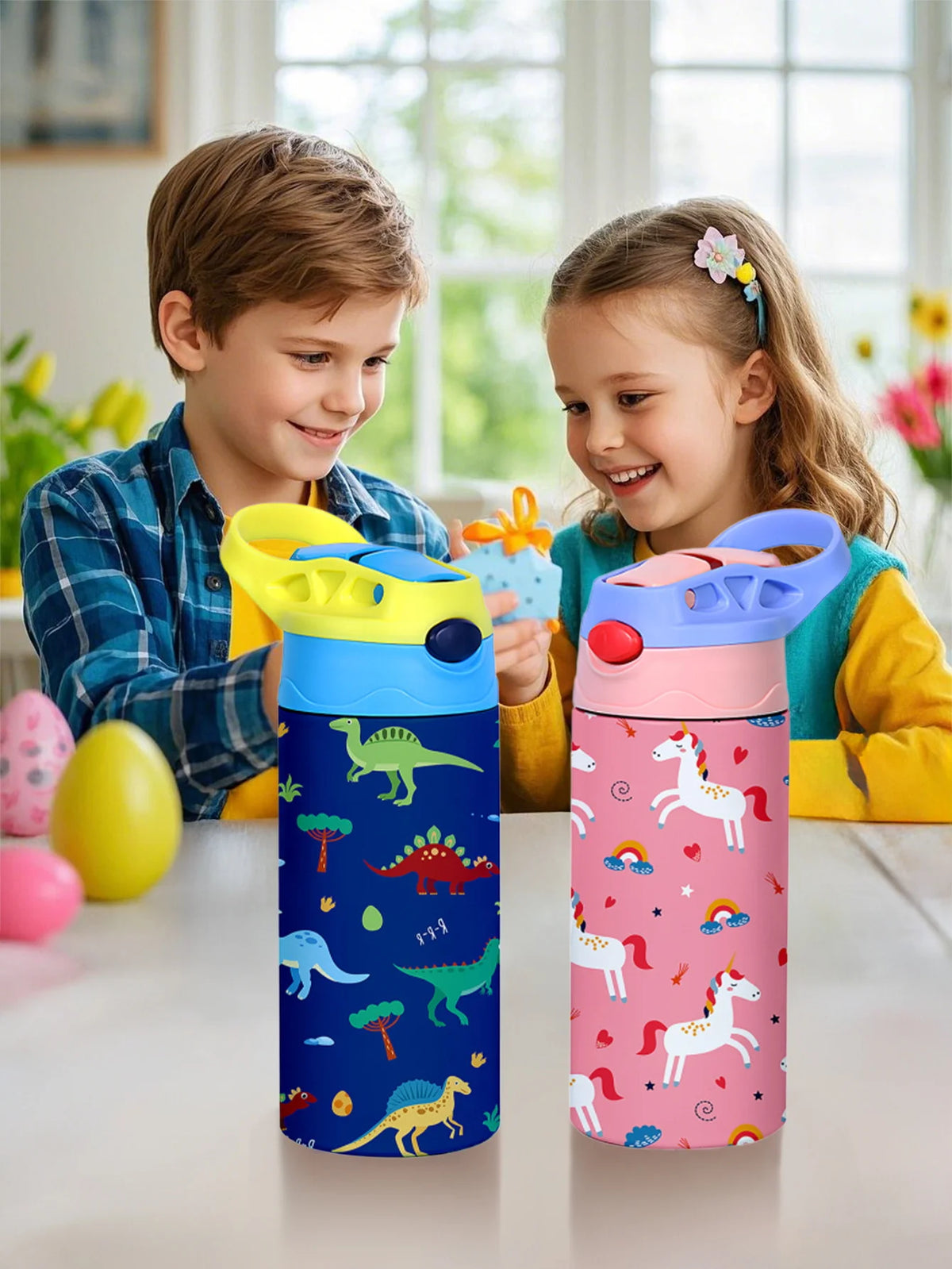 A pink and blue insulated stainless steel thermos cup featuring cartoon animal patterns, held by a child.
