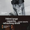 A close-up shot of a black portable electric shaker bottle with a transparent, faceted body, showing its convenient handle.