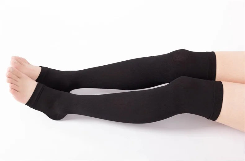 Black compression thigh high socks worn on a person's leg.