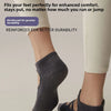 A close-up of a person wearing grey crisscross strap yoga socks on their feet.