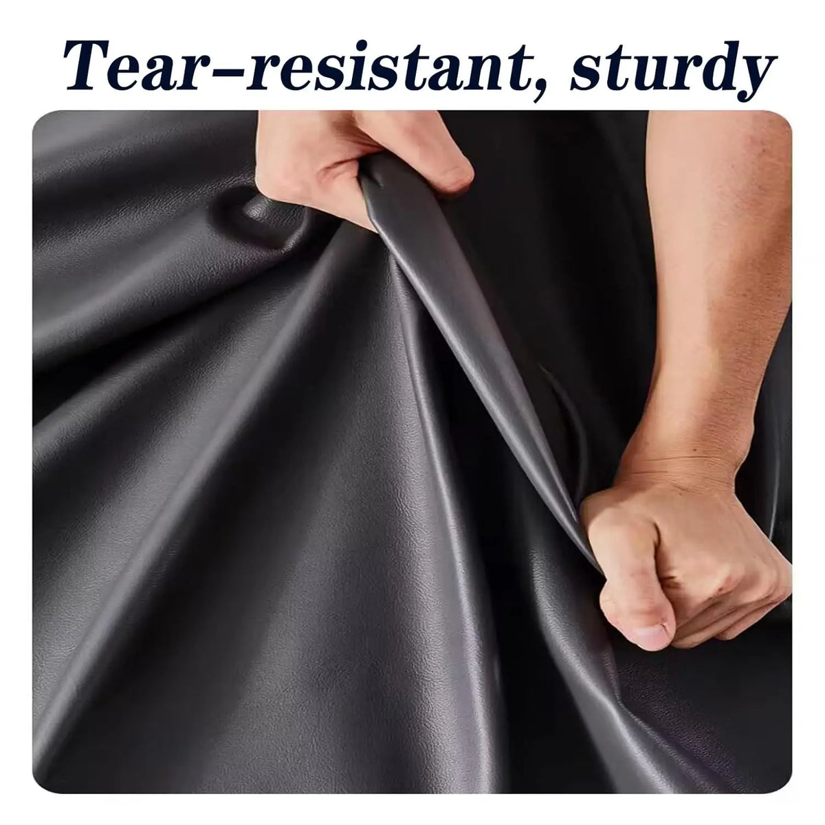 A hand is demonstrating the tear-resistant and sturdy nature of a black leather fabric.