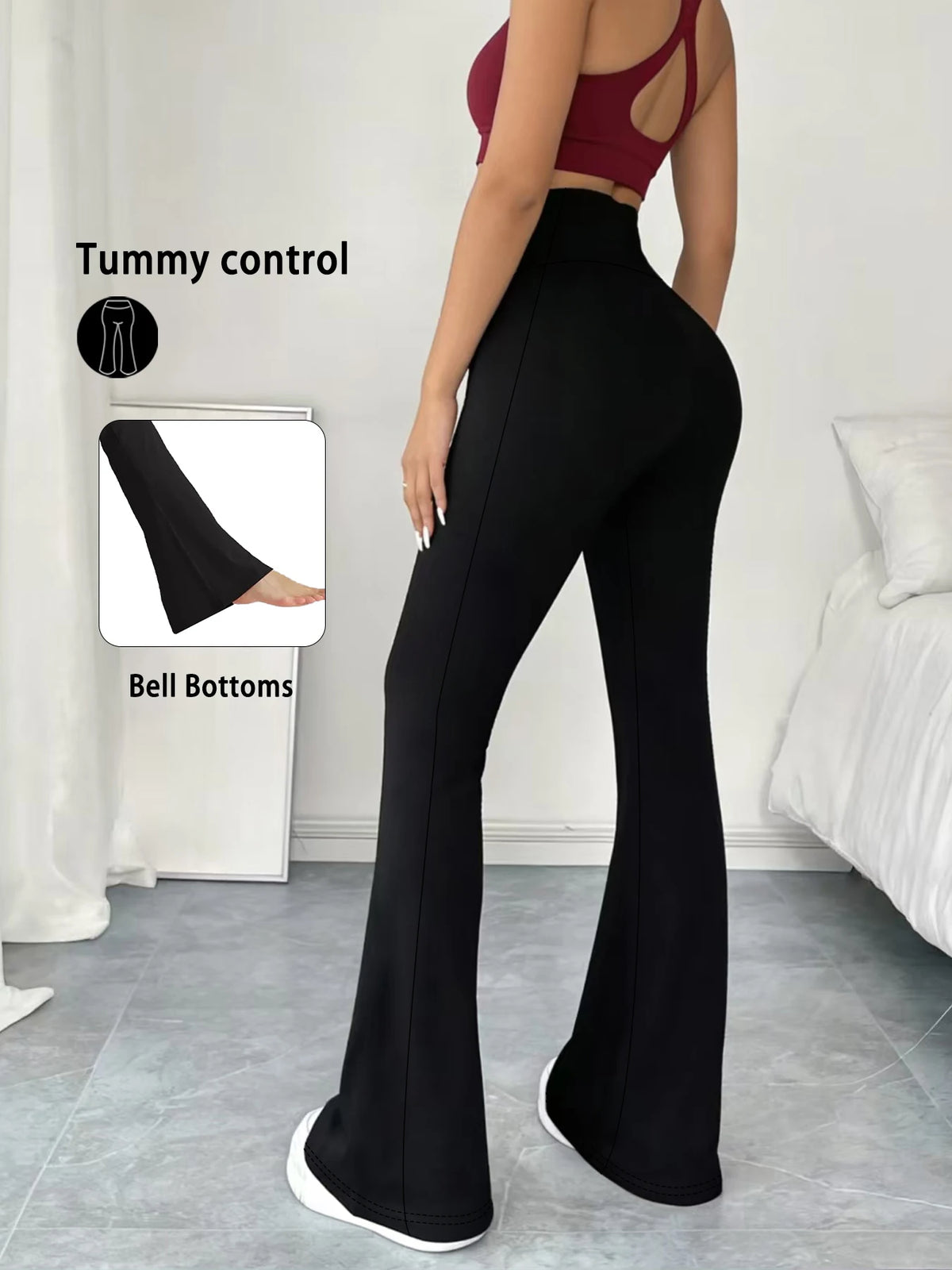 A woman wearing black high-waisted yoga leggings with flare details and a red crop top, demonstrating tummy control.
