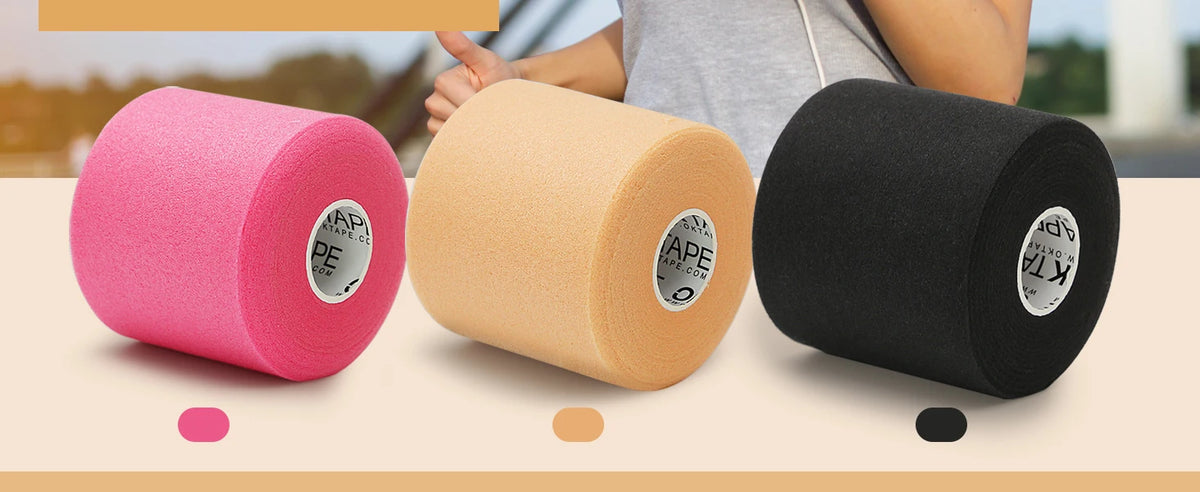 Three rolls of pink, beige, and black athletic foam tape are shown next to a person's hand.