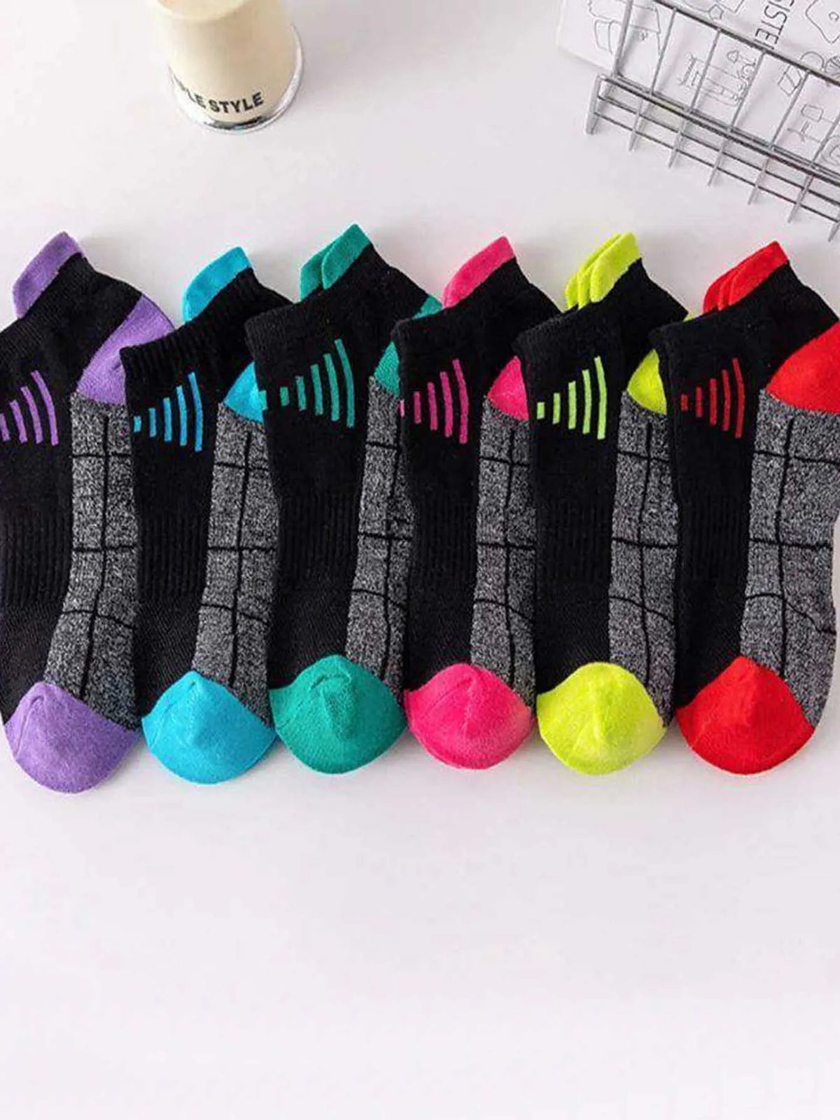Ein Set von sechs feuchtigkeitsableitenden, atmungsaktiven Sportsocken für Damen in verschiedenen Farben und Mustern.