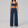 A woman wearing a navy blue two-piece yoga and sports tracksuit set consisting of a cropped top and full-length pants.