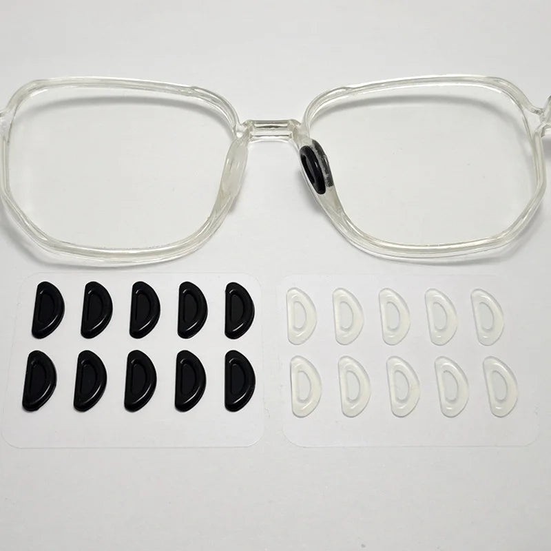 Clear plastic eyeglasses with black silicone anti-slip nose pads and spare clear nose pads.