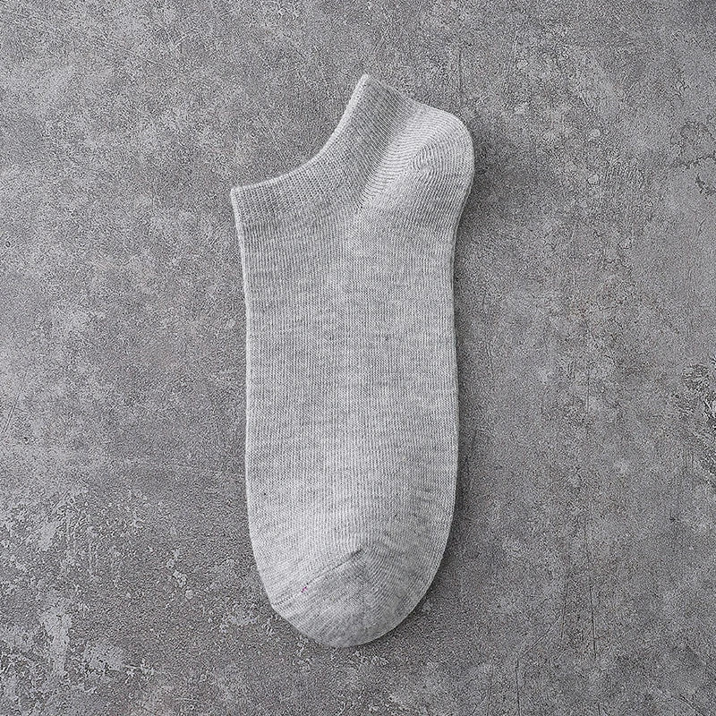 A single light gray ankle sock is displayed against a textured gray background.