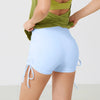 Light blue performance yoga shorts worn by a person, showing the fabric and fit.
