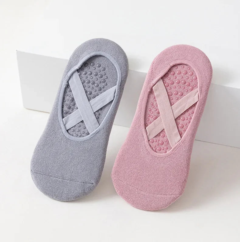 Pair of non-slip yoga and gym socks with silicone grip in gray and pink.