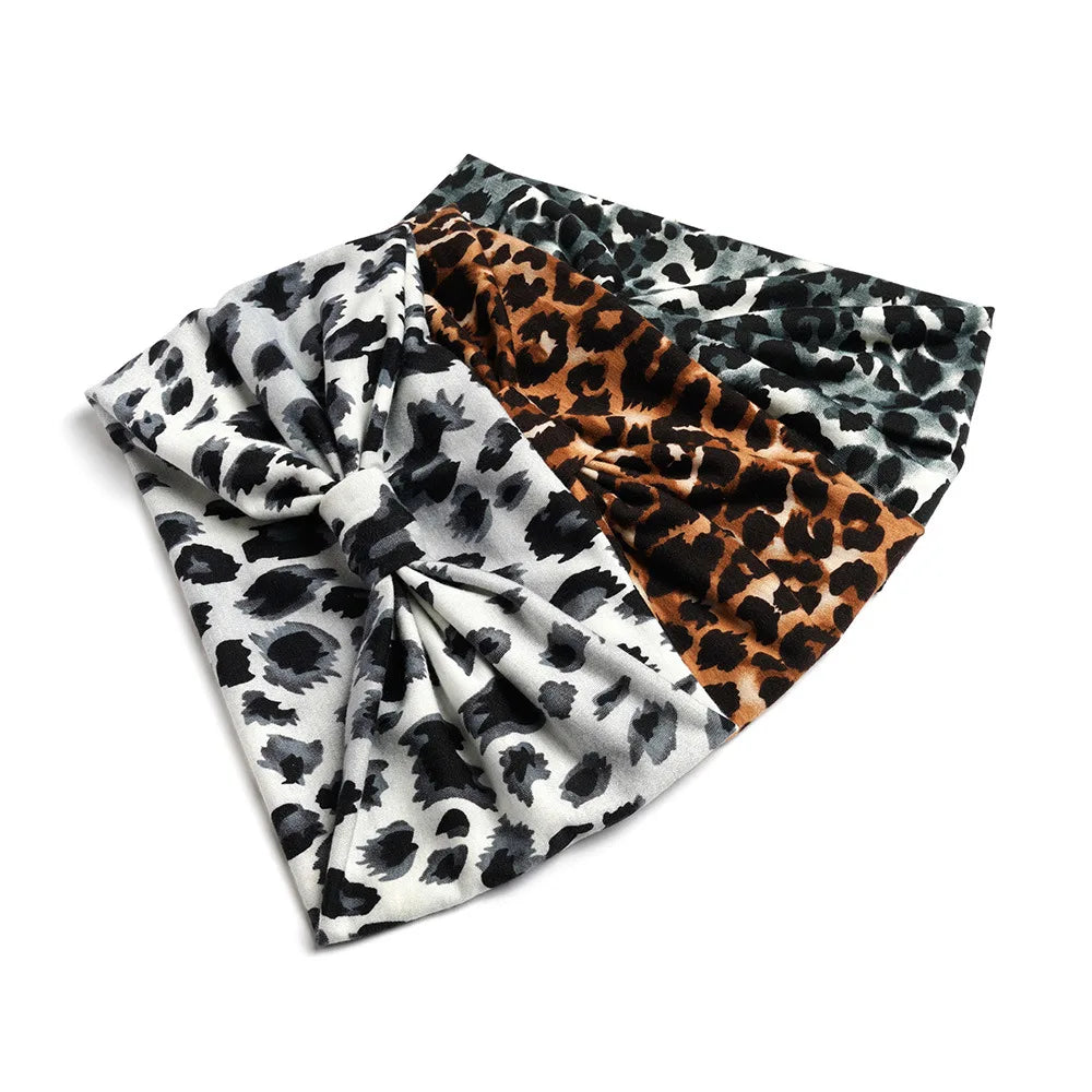 A folded bohemian cotton stretch headband featuring a black and white leopard print and a brown leopard print.