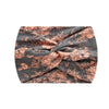 A close-up of a boho printed wide knotted headband in gray and terracotta floral pattern.