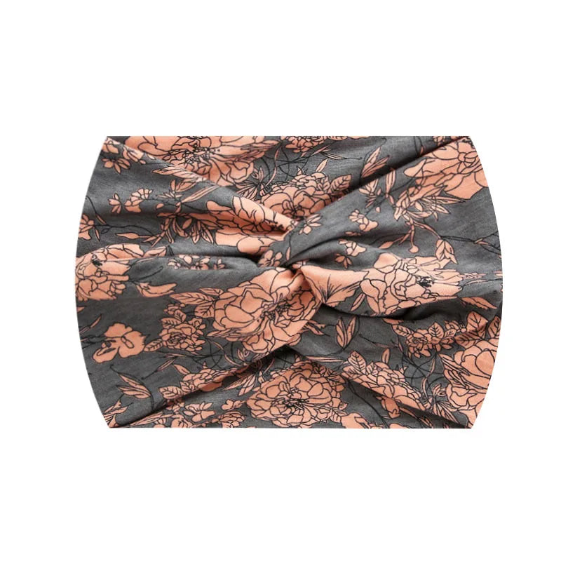 A close-up of a boho printed wide knotted headband in gray and terracotta floral pattern.