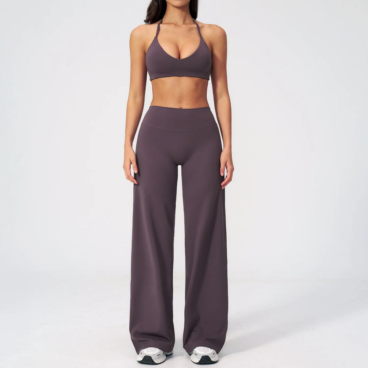 A woman wearing a dark purple women's premium fitness tracksuit top and pants.