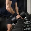 A person is using black wrist support straps on a piece of gym equipment for pain relief.