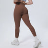 A model wearing high-waisted brown quick-drying yoga leggings and white sneakers.