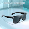 A pair of black frameless sunglasses resting on a light blue surface.