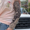 Una persona viste una camisa rosa y muestra una manga con un diseño oscuro y detallado en su antebrazo.