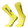 A pair of bright yellow football socks with black grip dots and ribbed texture.