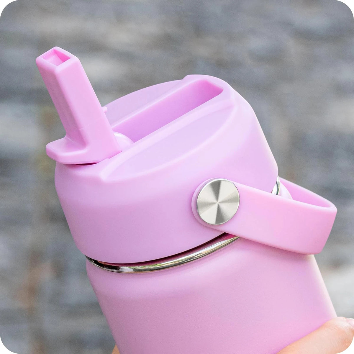 A pink secure straw lid for a wide mouth bottle is shown against a blurred gray background.