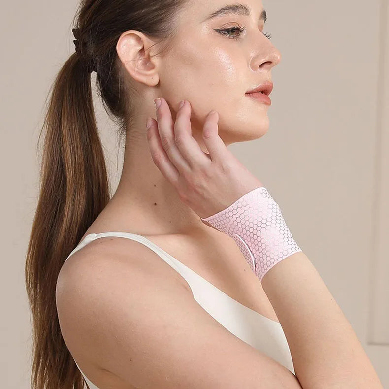 A woman wearing a pink ultra-thin spandex wrist guard for joint support on her arm.