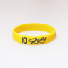 Yellow silicone wristband with the number 10 and a signature printed on it.