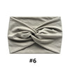 A light gray fabric item, likely a boho wide turban headband, is folded and displayed against a white background.