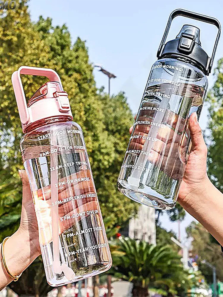 Eine Hand hält eine klare Wasserflasche mit Zeitmarkierungen, die verschiedene Hydratationsziele für den Tag zeigt.