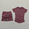 A mauve seamless yoga set for women featuring a short sleeve top and matching workout leggings.