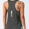 A woman wearing a dark gray running vest with a stylized cat design on the shoulder.
