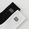 A pair of black and white men's classic crew socks with the number 23 printed on them.
