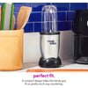 Una licuadora Magic Bullet plateada y negra sobre una encimera de cocina junto a un recipiente amarillo y azulejos azules.