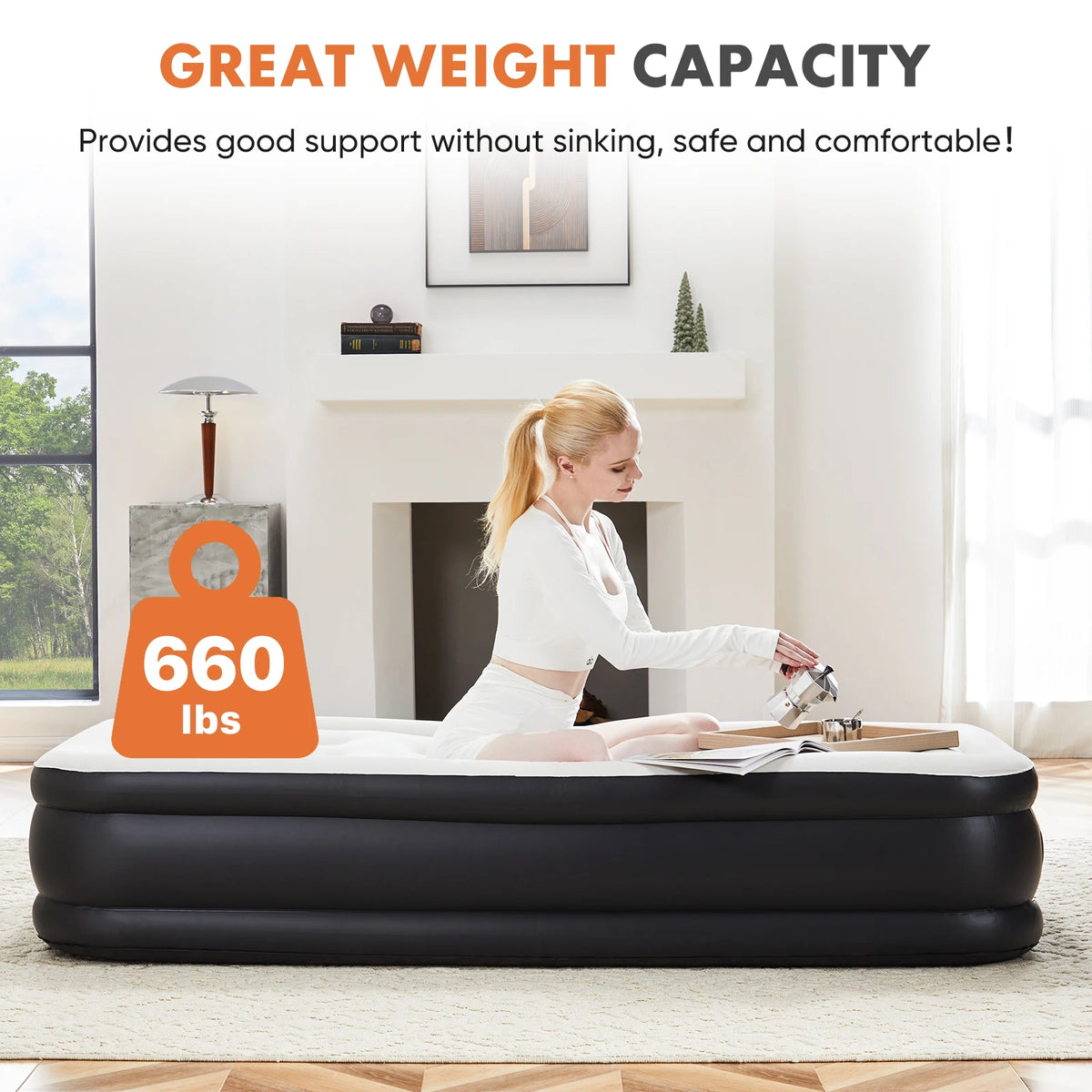 A woman is lying on a black air mattress with a weight capacity label indicating 660 lbs.