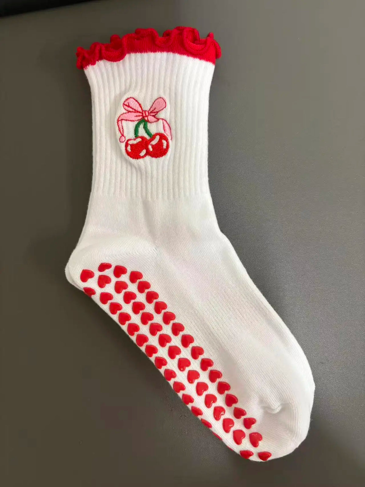 Weiße Strick-Yoga- und Fitnesssocken mit rohem Rüschenrand und Herzmuster auf der Sohle.