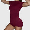 A model wearing a maroon seamless yoga set for women, featuring short sleeves and workout leggings.