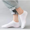 Calcetines náuticos blancos casuales y transpirables puestos en un pie contra un fondo gris claro.