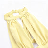 A yellow, gathered-neck dress with a draped cut-out back shown from the front.