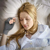 A woman with long blonde hair is wearing copper compression arthritis hand and wrist gloves while resting.