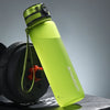Grüne wiederverwendbare Sportflasche mit Trageleine vor grauem Hintergrund
