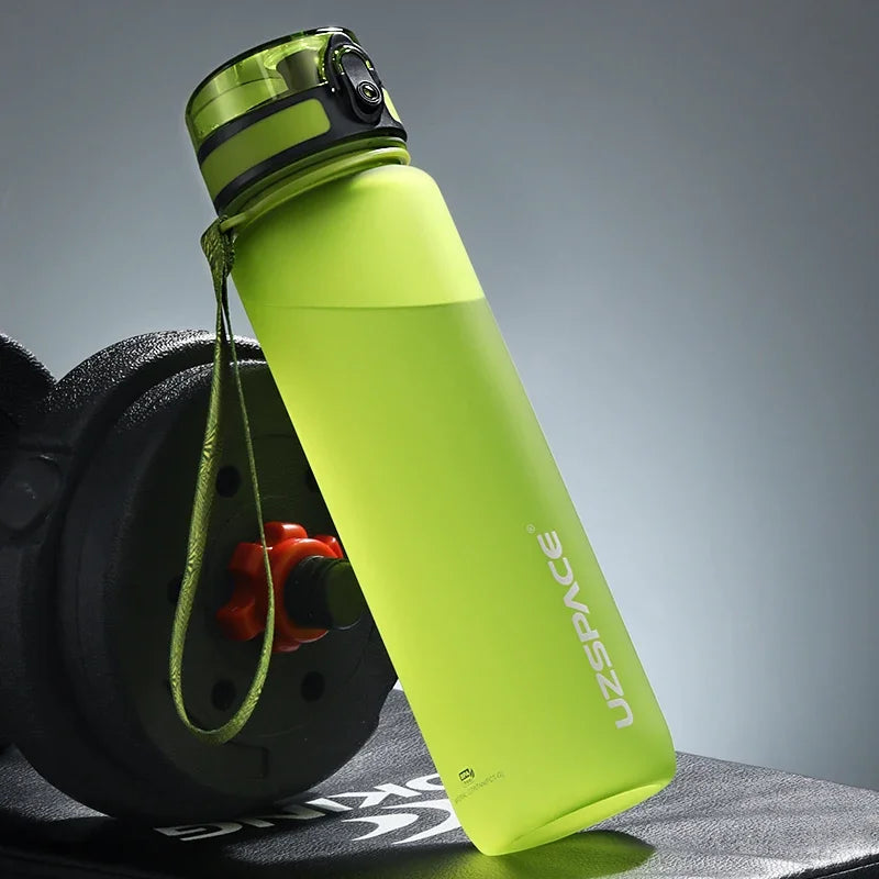 Grüne wiederverwendbare Sportflasche mit Trageleine vor grauem Hintergrund