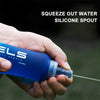 A hand squeezes water out of a blue silicone spout bottle for outdoor or fitness use.