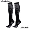 A pair of black compression socks with a dark grey patterned design shown against a white background.