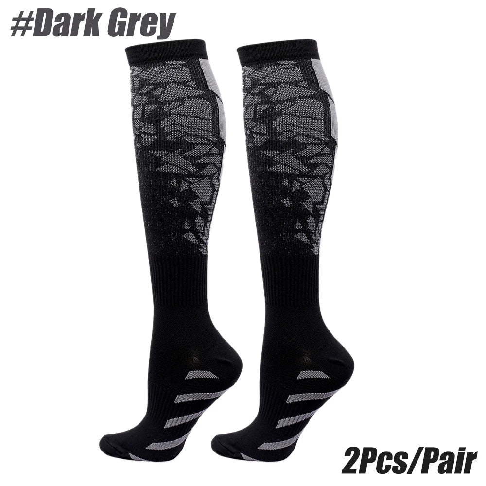A pair of black compression socks with a dark grey patterned design shown against a white background.