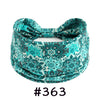 A teal patterned fabric headband tied in a bow, suitable for yoga or workout.