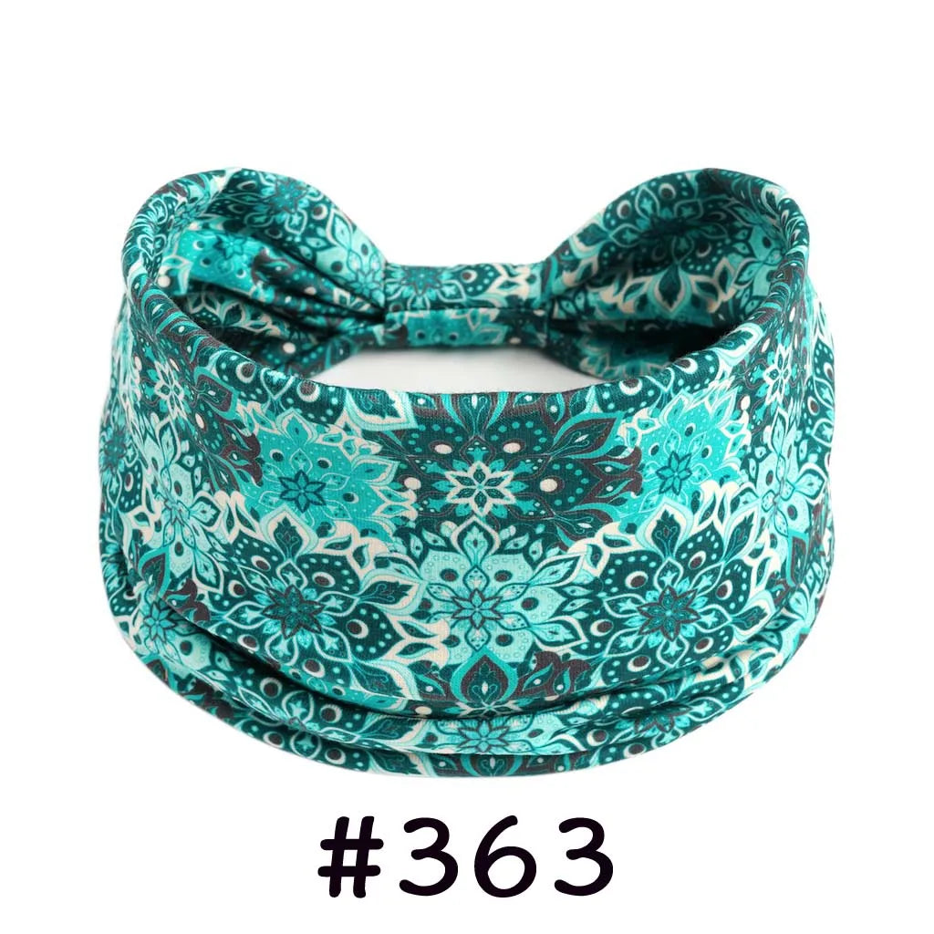 A teal patterned fabric headband tied in a bow, suitable for yoga or workout.