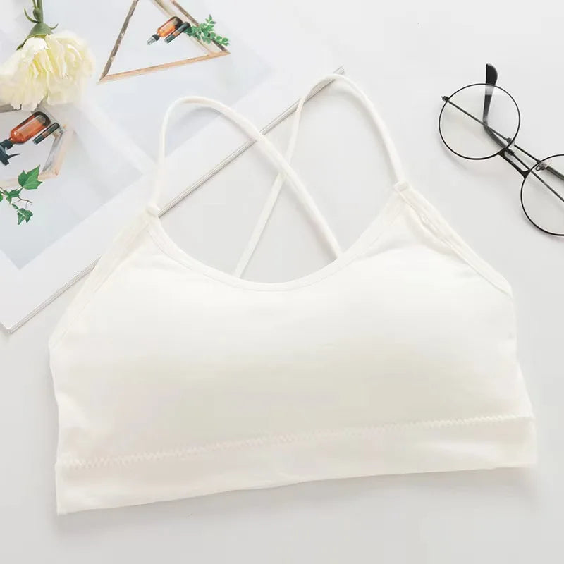 A white women's cross strap sports bra laid flat on a light surface.