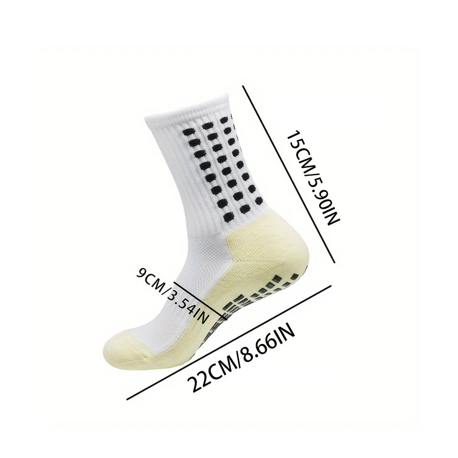 A pair of white non-slip football leg sleeves with black dots and yellow accents shown from the side.