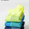 Stapel von Kompressions-Sportstrümpfen in verschiedenen Farben, darunter Neon-Gelb, Blau und Schwarz.