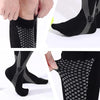 Close-up view of black compression socks with gray patterned fabric on a foot and leg.